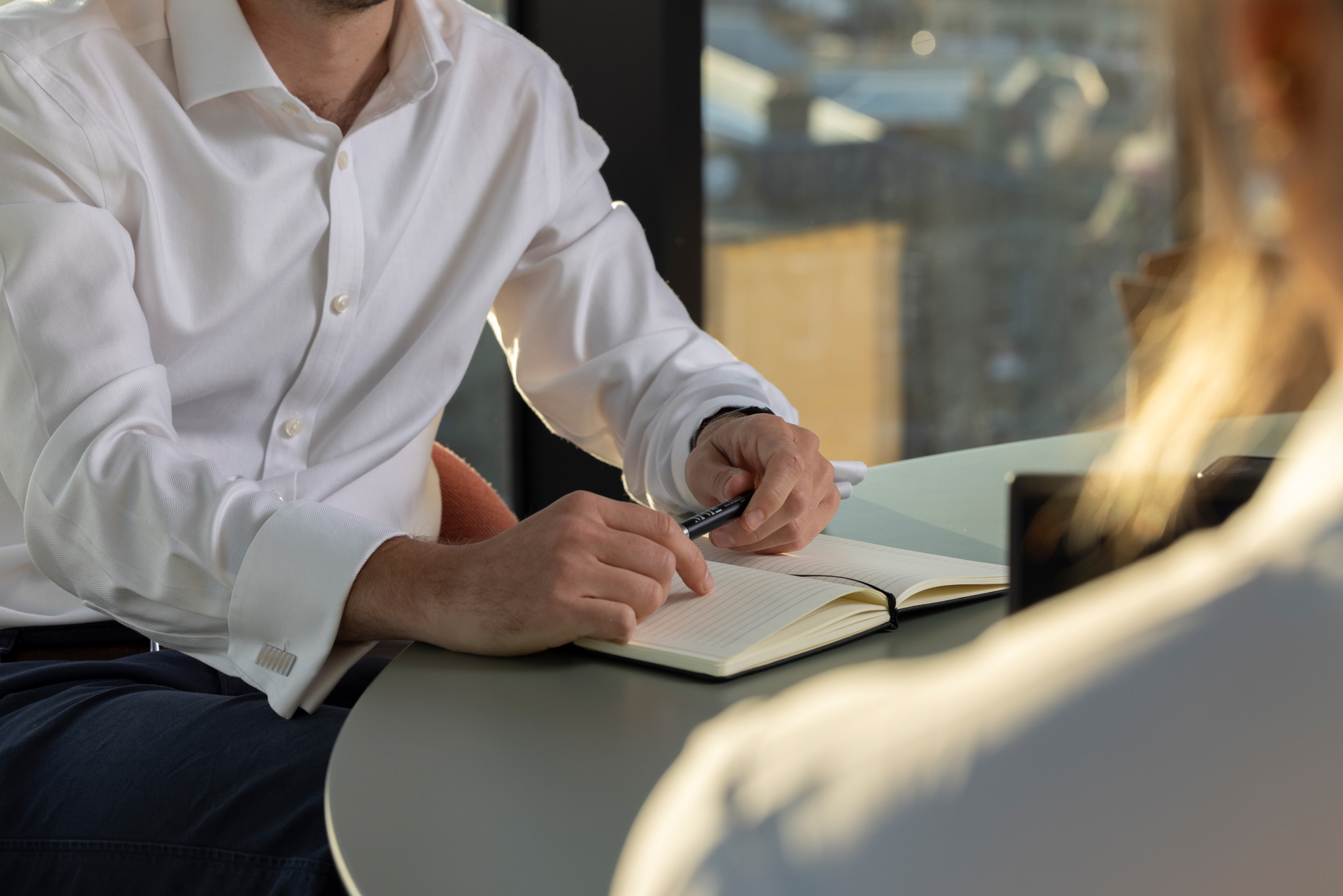 Professional meeting discussing debt recovery strategy, with notes being taken during a client discussion.